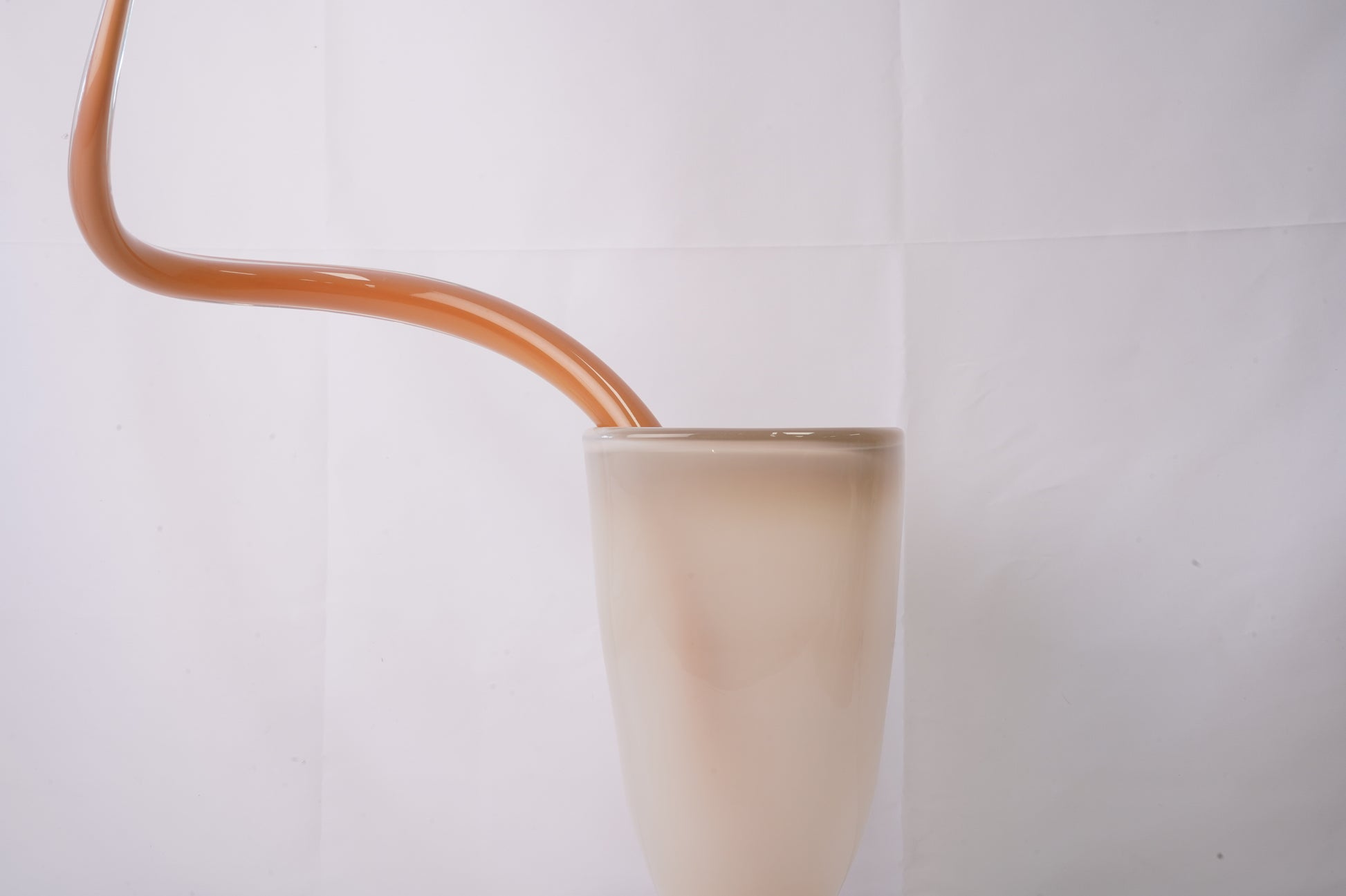 beige milky hand-blown glass vase with sculptural handblown glass flowers and orange prongs, creating a bold, artistic statement piece for interiors