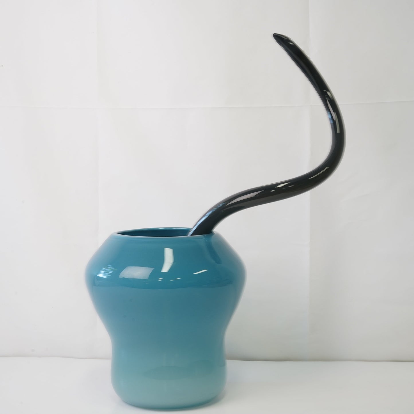 blue hand-blown glass vase with sculptural handblown glass flowers and black prongs, creating a bold, artistic statement piece for interiors