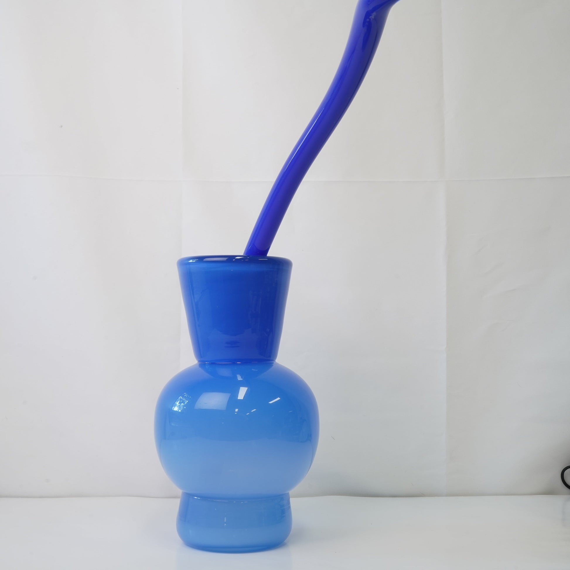 blue hand-blown glass vase with sculptural handblown glass flowers and blue prongs, creating a bold, artistic statement piece for interiors