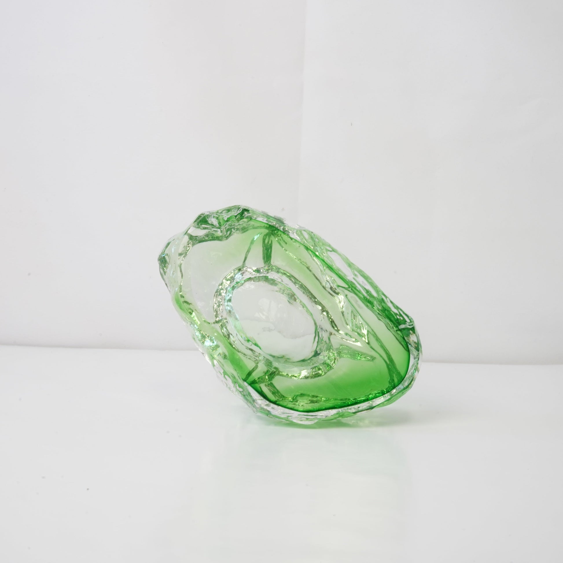 A textured green glass sculptural piece
Handcrafted green glass object with textured finish
