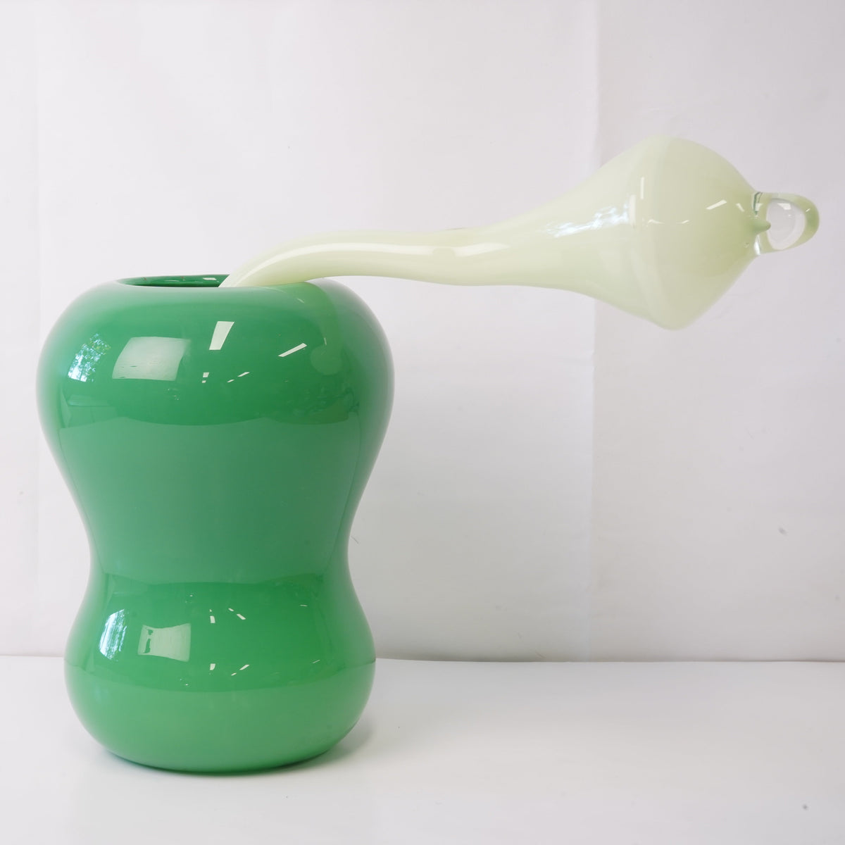 green hand-blown glass vase with sculptural handblown glass flowers and mint prongs, creating a bold, artistic statement piece for interiors