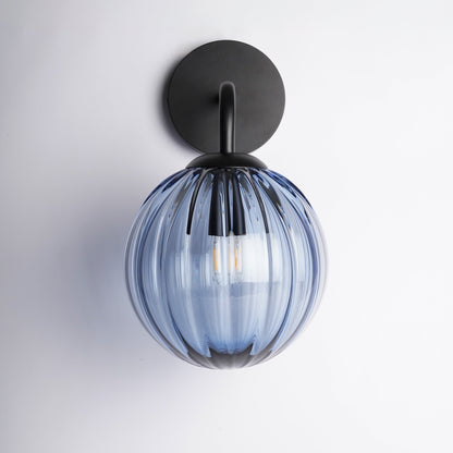 Wall-mounted light fixture with blue glass shade on a white background