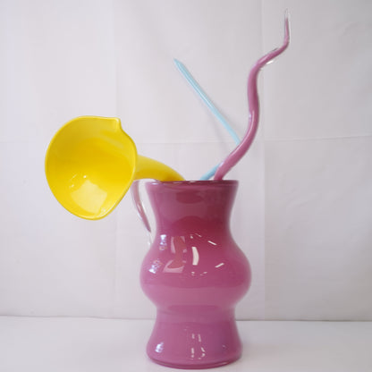pink hand-blown glass vase with sculptural handblown glass flowers and yellow prongs, creating a bold, artistic statement piece for interiors