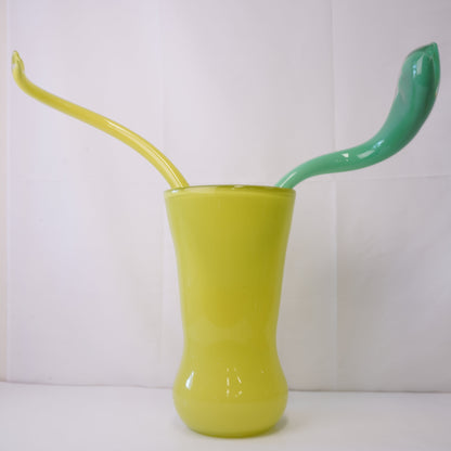 yellow hand-blown glass vase with sculptural handblown glass flowers and yellow and green prongs, creating a bold, artistic statement piece for interiors